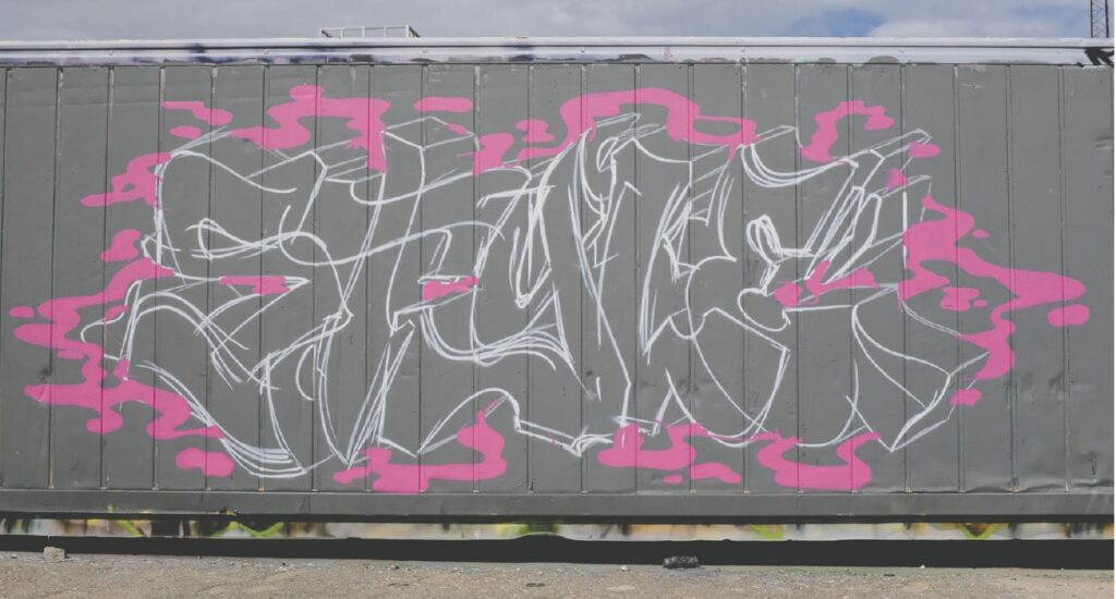 Wall with highlighted white graffiti text with added pink layer