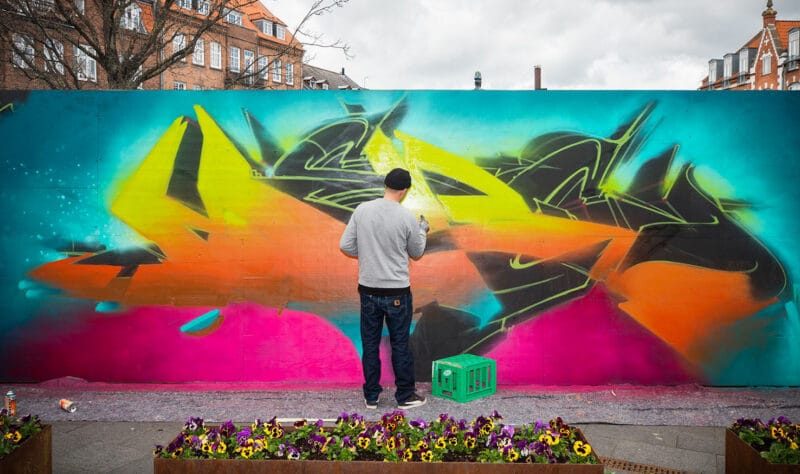 GraffitiBible making graffiti on a wall